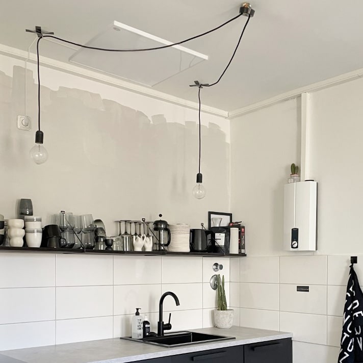 Een witte plafondverwarmer hangt aan het plafond in een keuken.