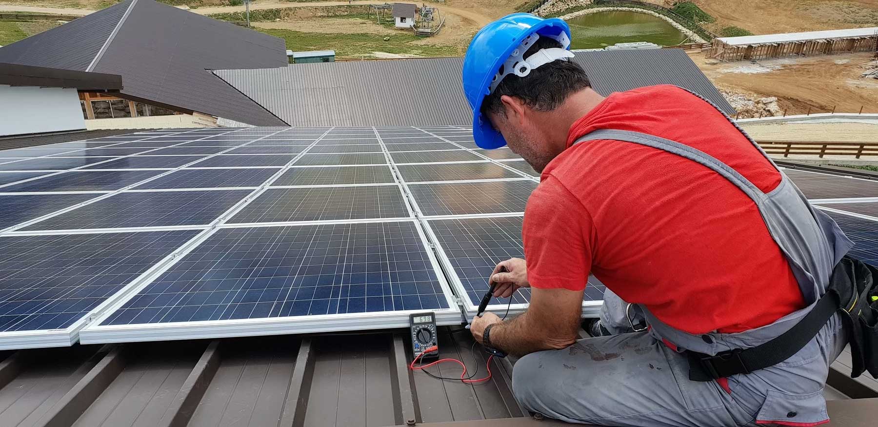Man installeert een fotovoltaïsch systeem op het dak.